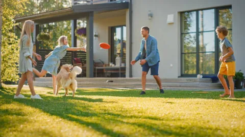 Family playing in a backyard with a healthy lawn