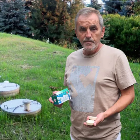 Septifix customer holding a box and tablet next to septic tank lids